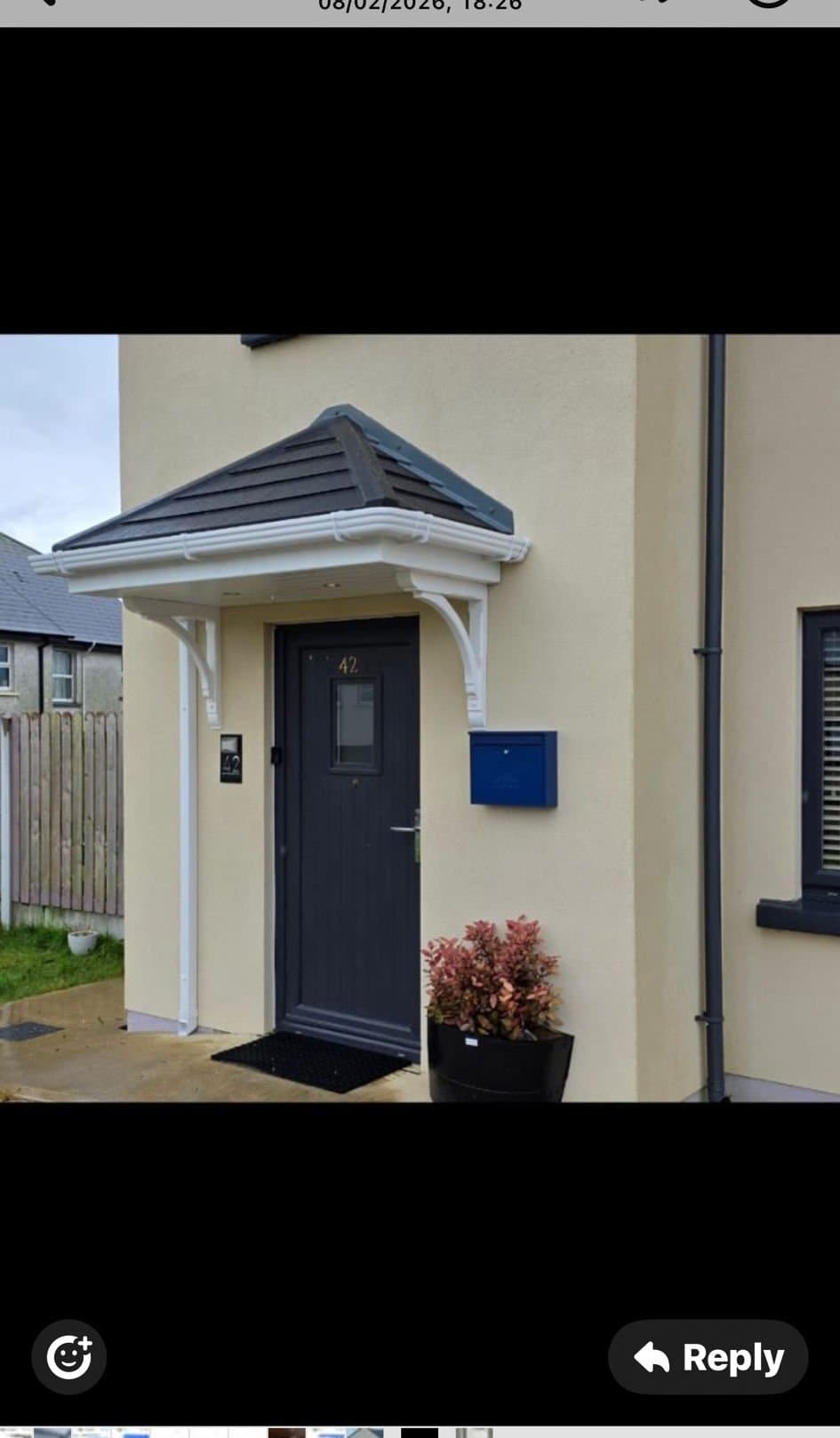 Grey hip roof canopy with white columns fitted on new build home