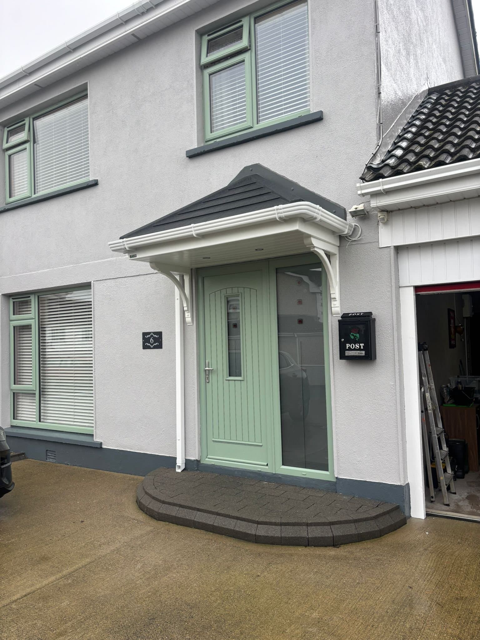 White hipped canopy with sidelight over green front door on residential home