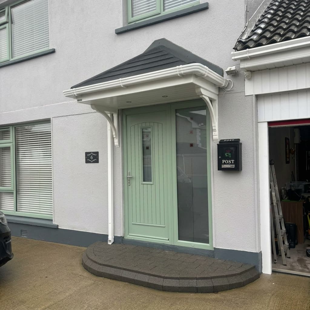 White hipped canopy with sidelight over green front door on residential home